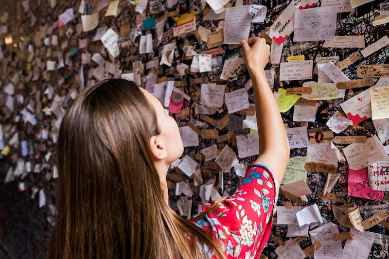 ragazza che lascia bigliettini al balcone di Giulietta a Verona